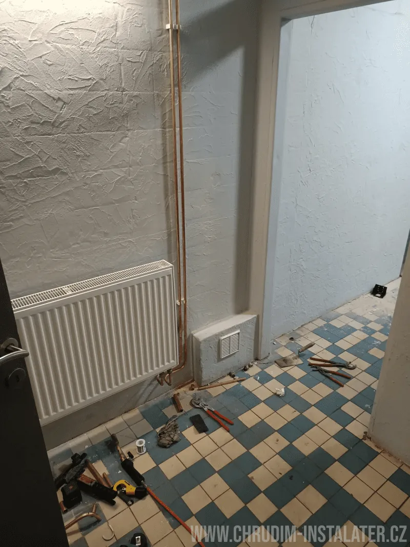 Radiátor a měděné rozvody topení během instalatérských prací